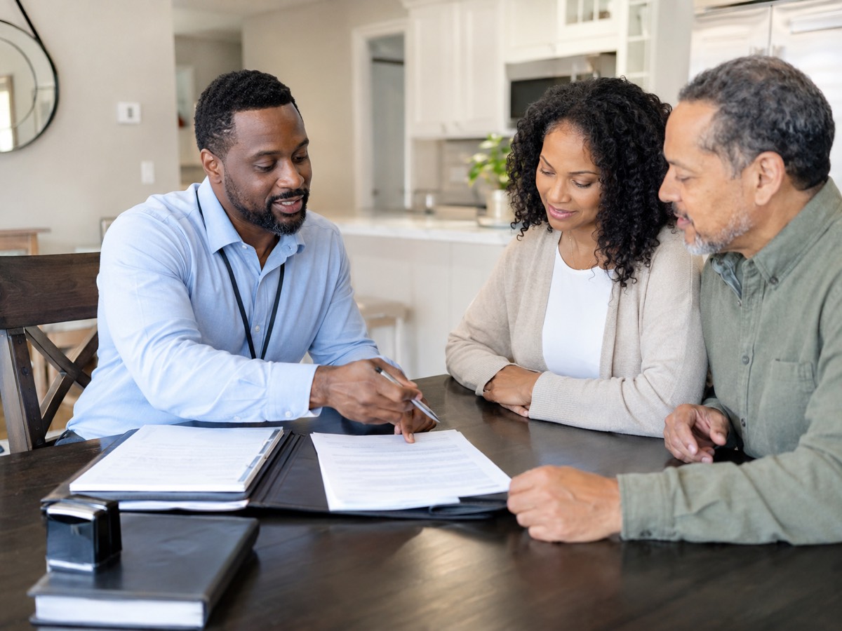 Mobile notary walking a couple through trust and estate planning documents at home